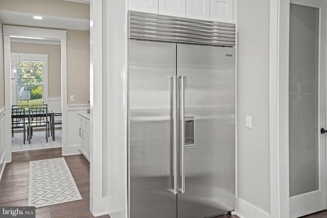 kitchen with white cabinetry, stainless steel built in fridge, and dark wood-type flooring