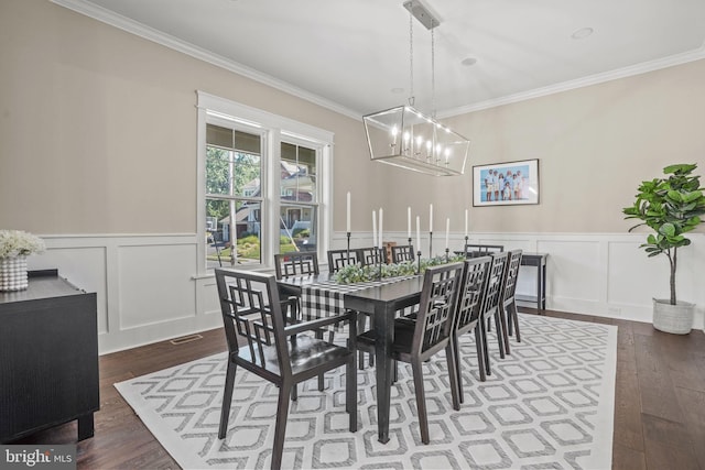 dining area featuring crown molding, dark hardwood / wood-style floors, and a chandelier