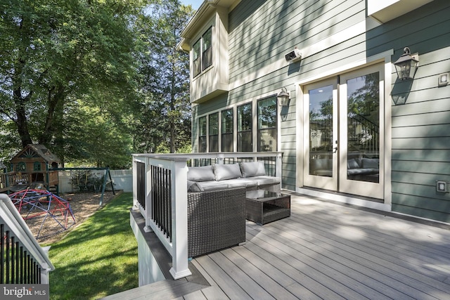 wooden deck featuring french doors, outdoor lounge area, a playground, and a lawn