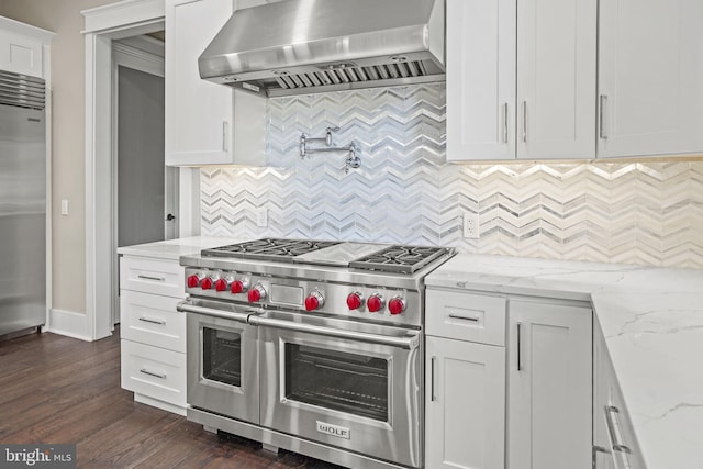 kitchen featuring dark hardwood / wood-style floors, range hood, high quality appliances, white cabinetry, and light stone counters