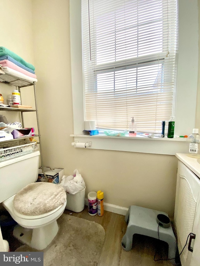 bathroom with hardwood / wood-style flooring, toilet, and vanity