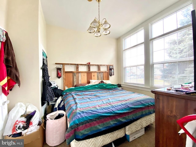 carpeted bedroom featuring a notable chandelier