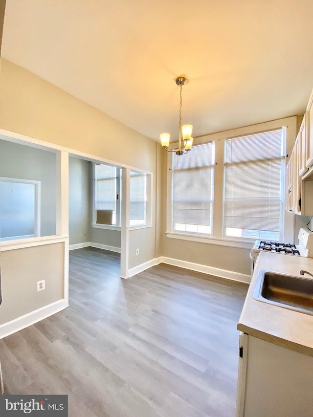 kitchen featuring an inviting chandelier, dark hardwood / wood-style flooring, hanging light fixtures, white cabinetry, and sink