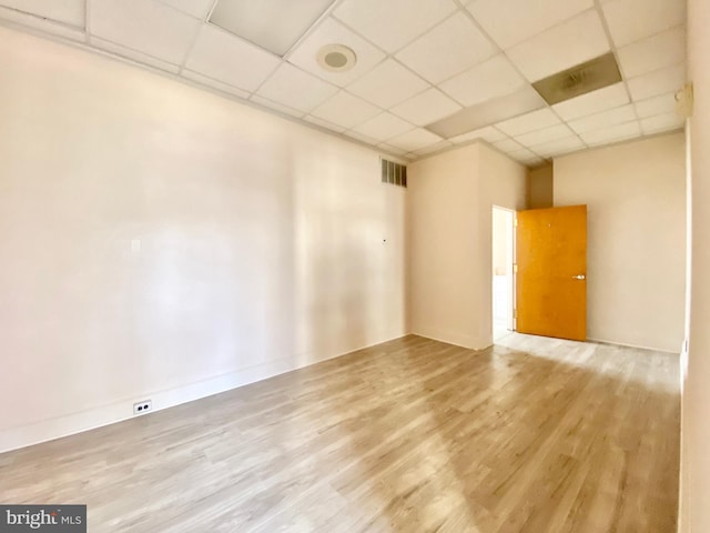 empty room featuring light hardwood / wood-style flooring and a drop ceiling