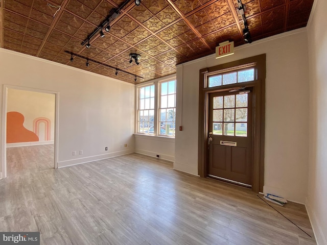 entryway with ornamental molding and hardwood / wood-style flooring