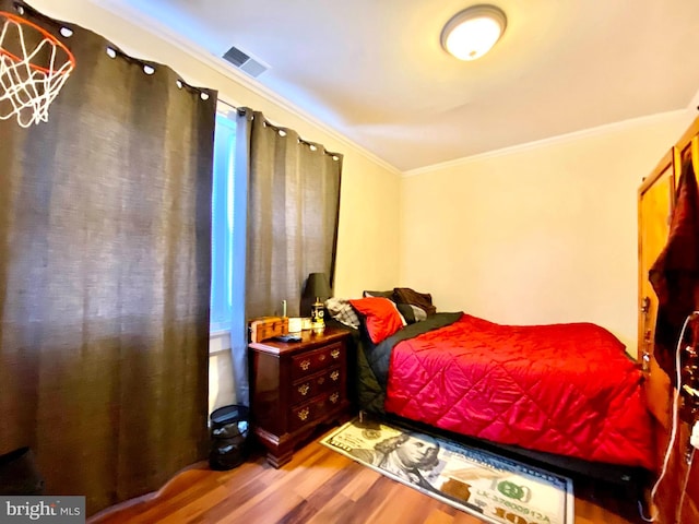 bedroom featuring crown molding and hardwood / wood-style flooring