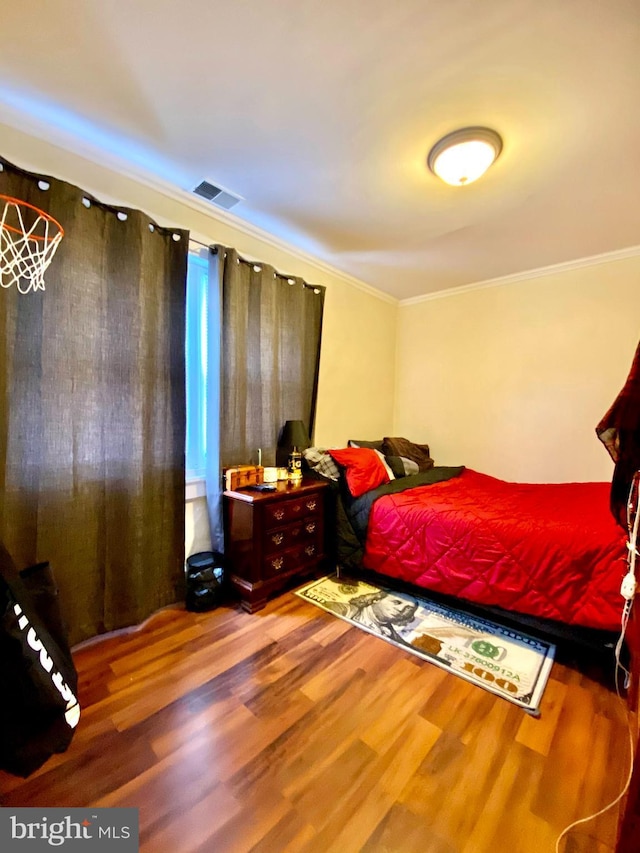 bedroom with crown molding and hardwood / wood-style flooring