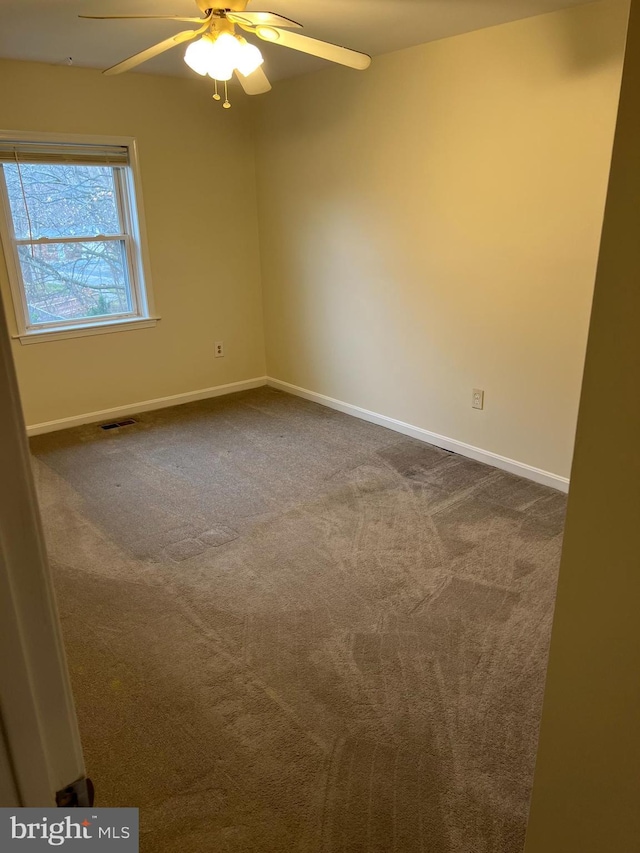 carpeted spare room featuring ceiling fan