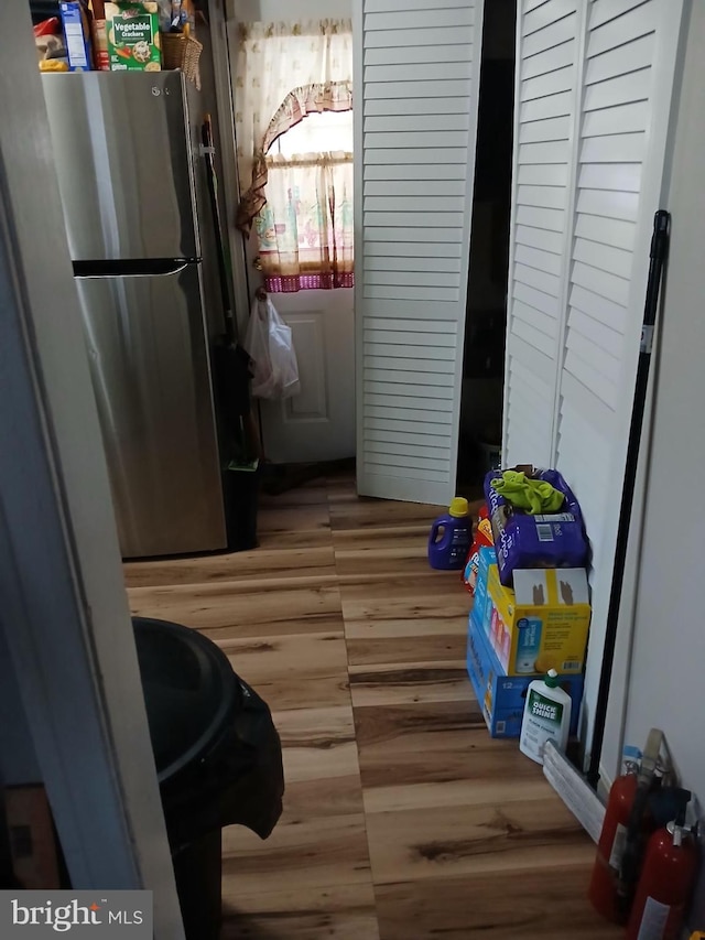 interior space featuring hardwood / wood-style floors, stainless steel fridge, and blue cabinets