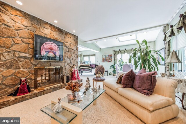 living room with vaulted ceiling with skylight and a fireplace