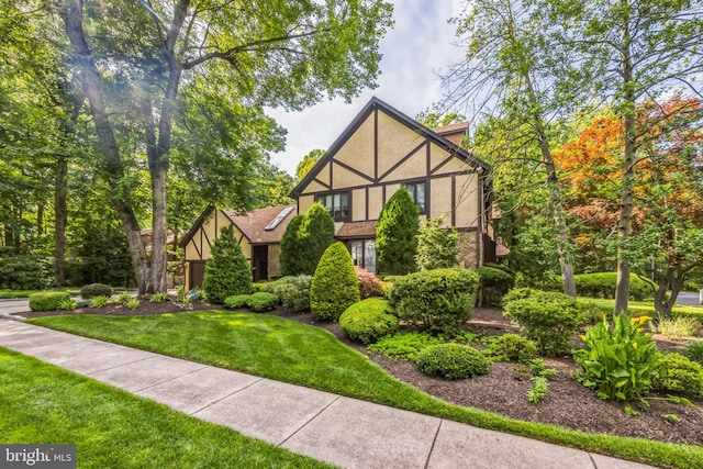 tudor-style house featuring a front yard