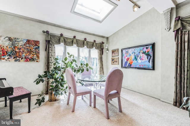 dining area featuring light carpet, rail lighting, and vaulted ceiling with skylight