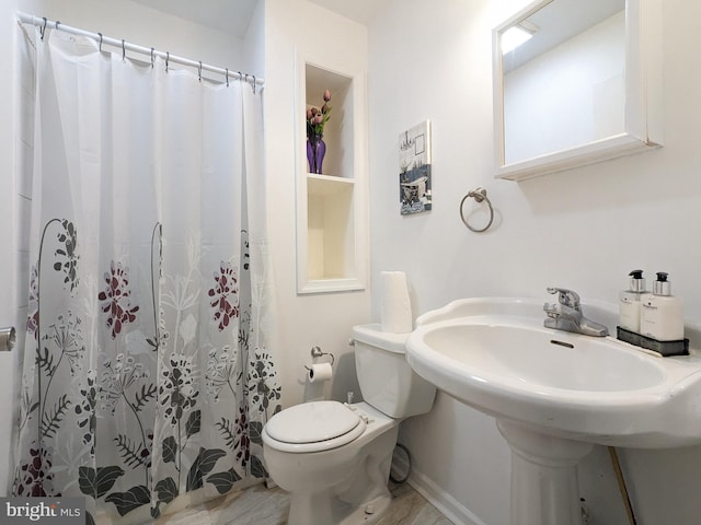 bathroom with curtained shower, toilet, and sink