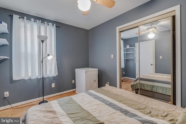 bedroom with ceiling fan, a closet, light hardwood / wood-style floors, and fridge