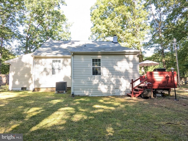 back of property featuring a lawn and central air condition unit