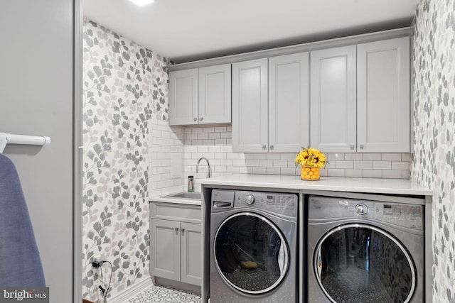 laundry area featuring cabinets, washing machine and dryer, and sink