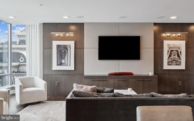 living room with hardwood / wood-style floors and wood walls