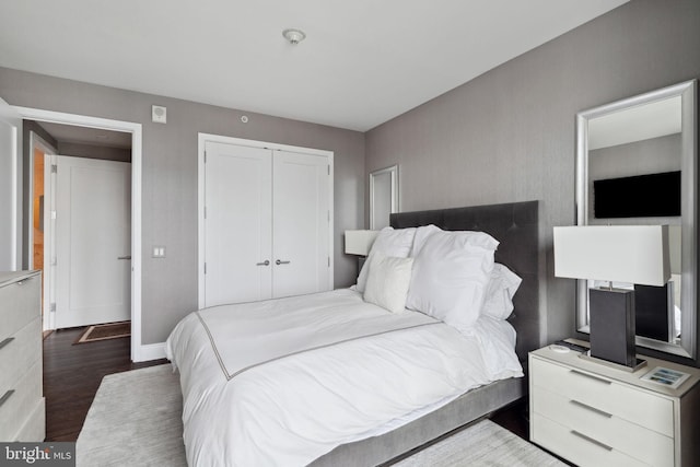 bedroom with a closet and dark wood-type flooring