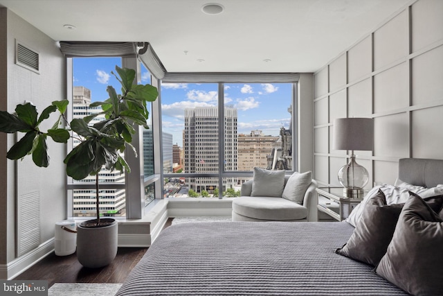 bedroom featuring floor to ceiling windows and dark hardwood / wood-style flooring