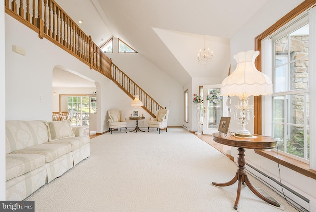 carpeted living room with baseboard heating, high vaulted ceiling, and a notable chandelier