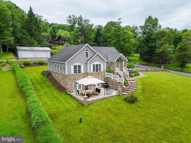 rear view of property featuring an outbuilding, a gazebo, central AC, a patio area, and a lawn