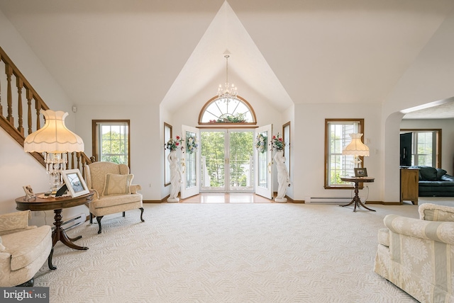 interior space with high vaulted ceiling, light colored carpet, and an inviting chandelier