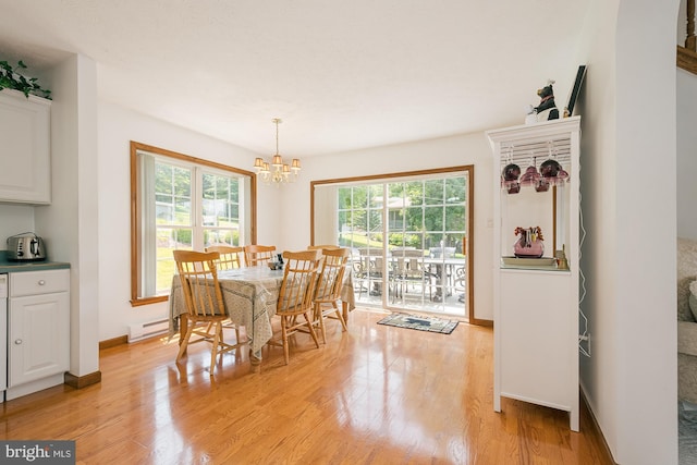 dining room with a notable chandelier, light hardwood / wood-style floors, plenty of natural light, and a baseboard heating unit