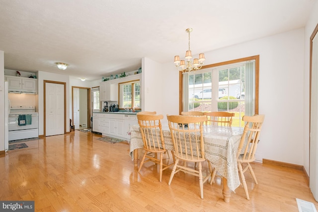 dining space featuring a chandelier, light hardwood / wood-style floors, and a wealth of natural light