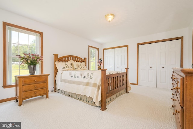 bedroom with multiple closets and carpet