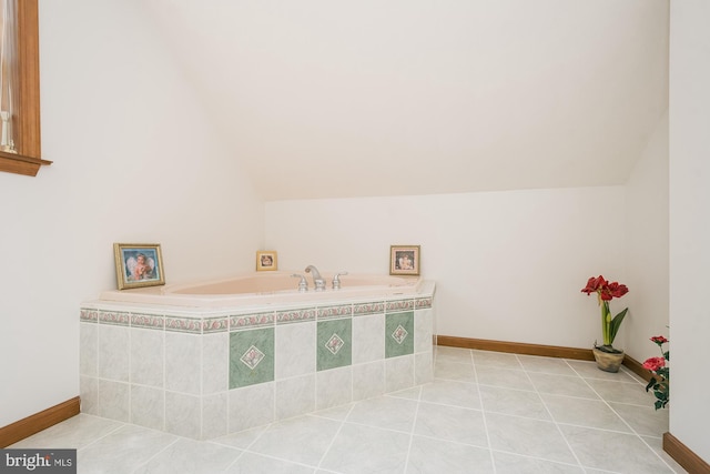 bathroom featuring tiled bath, tile patterned flooring, and lofted ceiling