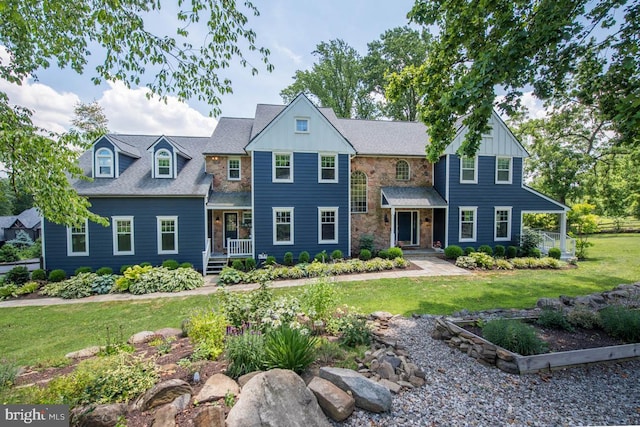 view of front facade featuring stone siding, covered porch, board and batten siding, and a front yard