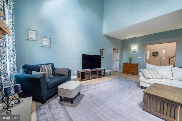 living room with wood finished floors and a towering ceiling