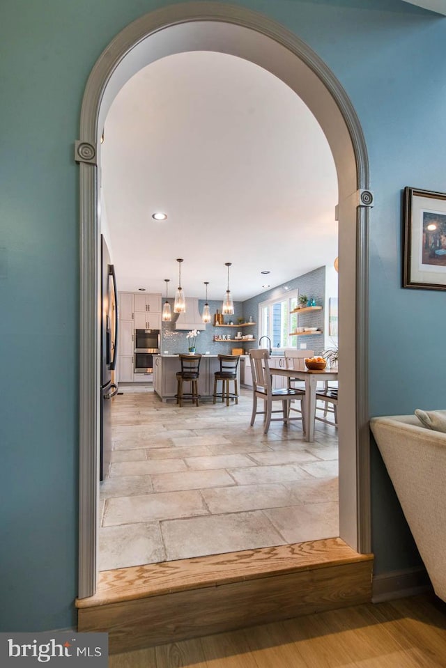 dining area with recessed lighting and arched walkways