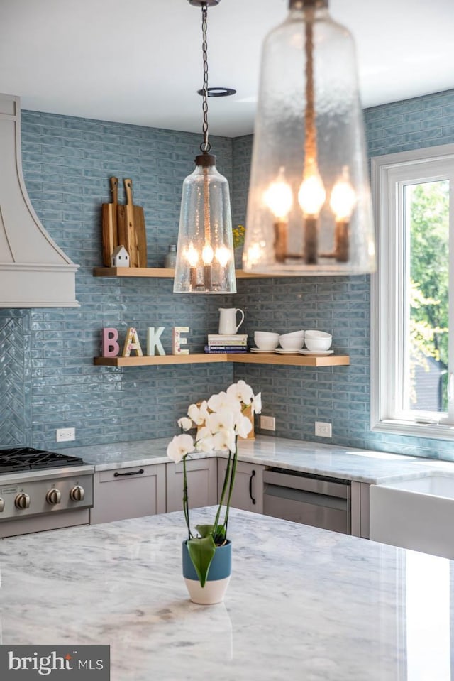 room details with light stone counters, decorative backsplash, stainless steel appliances, and open shelves