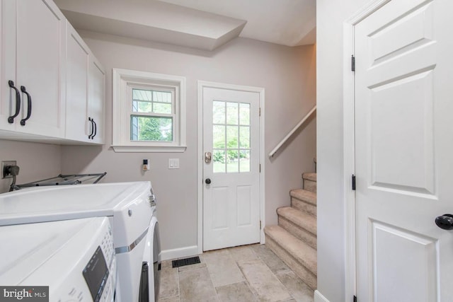 laundry area with cabinet space, baseboards, and washer and clothes dryer