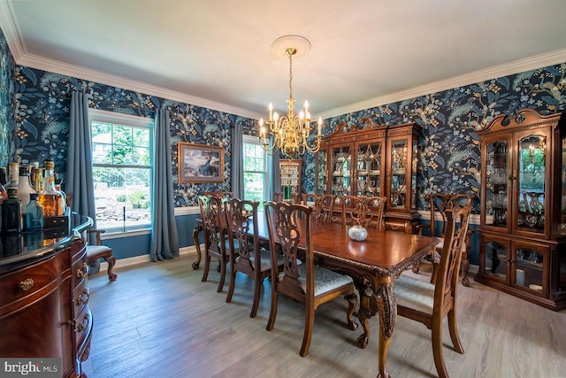 dining room with baseboards, wood finished floors, ornamental molding, and wallpapered walls