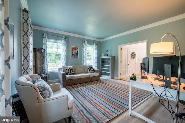 living room featuring crown molding, baseboards, and wood finished floors