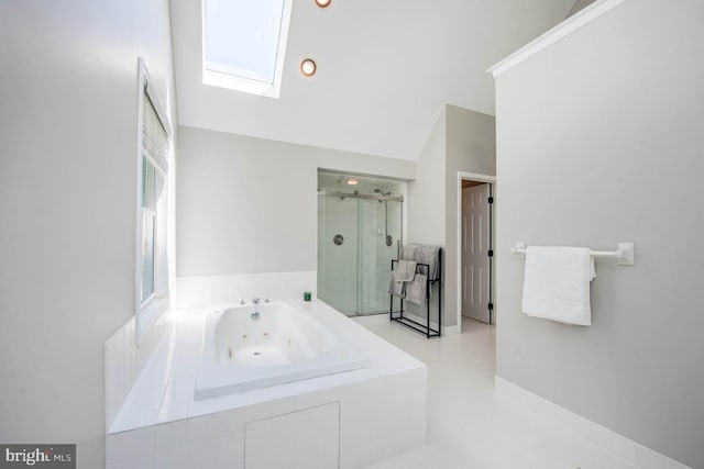 full bath featuring lofted ceiling with skylight, a shower stall, and a jetted tub