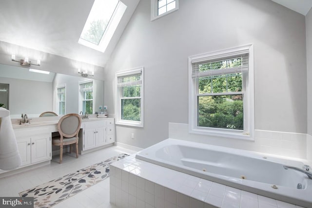 bathroom with a wealth of natural light, a whirlpool tub, a skylight, and vanity