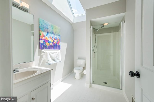 bathroom with vanity, a skylight, toilet, and a stall shower