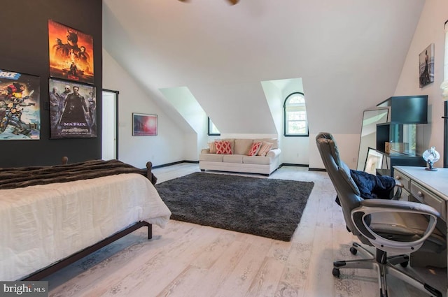 bedroom featuring lofted ceiling, wood finished floors, and baseboards