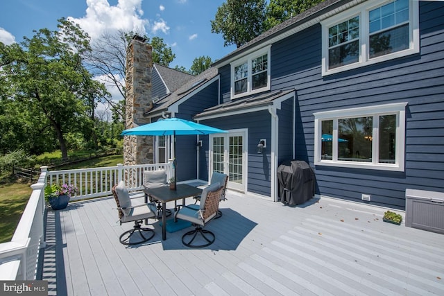 deck with outdoor dining area, french doors, and grilling area