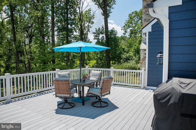 deck with grilling area and outdoor dining space