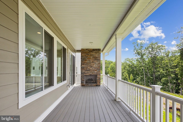 deck with an outdoor stone fireplace