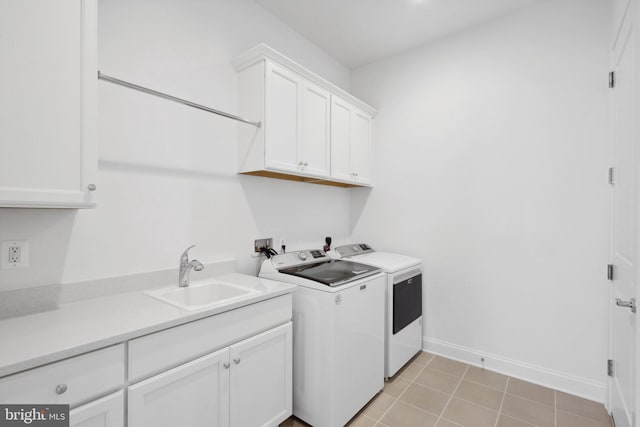 laundry area with light tile patterned floors, washing machine and dryer, sink, and cabinets