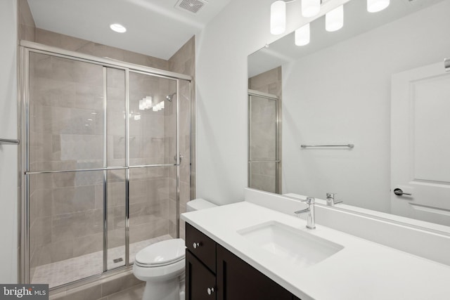 bathroom featuring toilet, tile patterned floors, walk in shower, and vanity