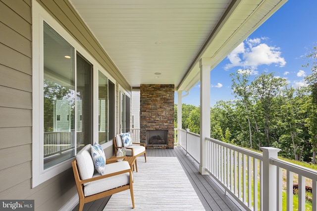 deck with an outdoor stone fireplace