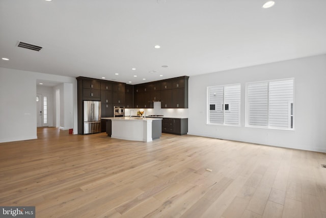 unfurnished living room featuring sink and light wood-type flooring