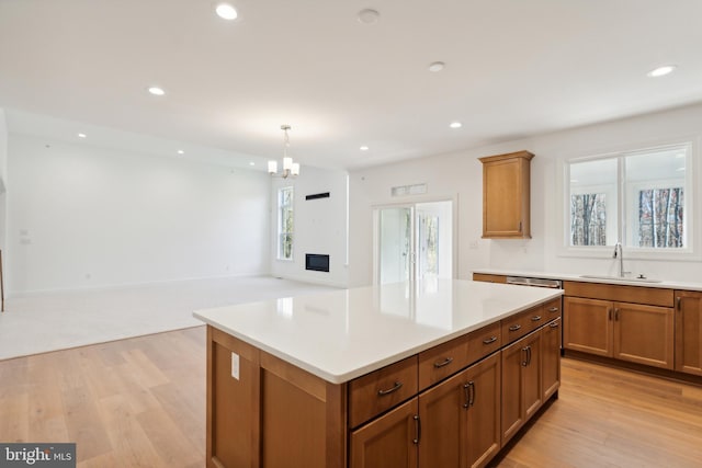 kitchen featuring sink, a center island, pendant lighting, and light hardwood / wood-style floors