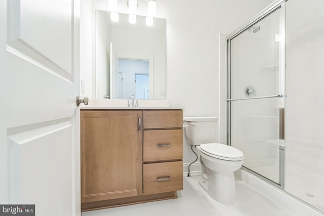 bathroom with tile patterned floors, vanity, a shower with shower door, and toilet